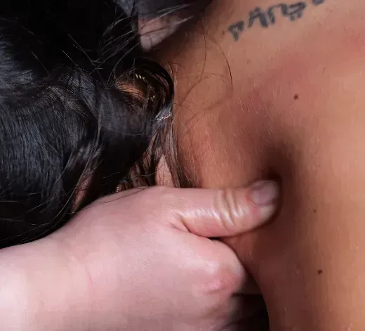 Therapeutin von NaturaMedic behandelt Nacken und Schulter einer Kundin
